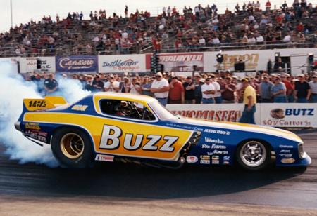 VintageMuscleCar, dragster, side view, race track, smoke trail, people, outdoors, 4K, highly detailed, (stylish grainy analog 35mm film photo, "BUZZ")