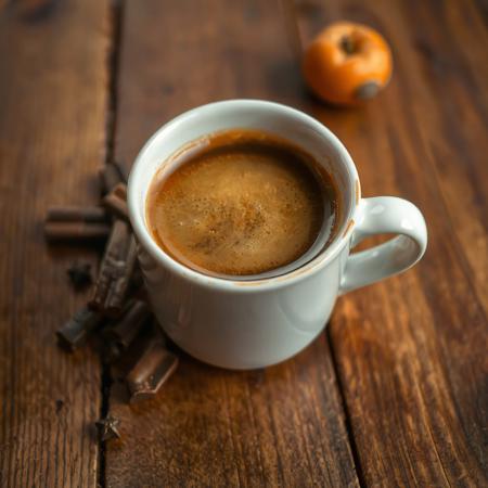 A cup of coffee on a wooden table, with hints of flavor Chocolate, Vanilla, Apricot, Pepper. вид спереди по горизонтом.