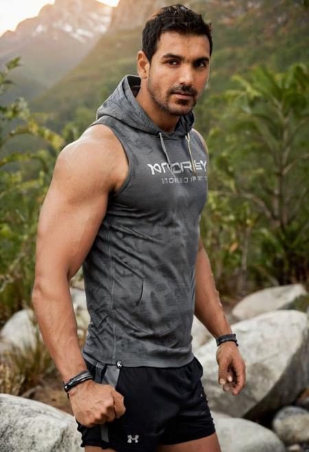 photo of mats hummels a man <lora:john-abraham_Mats-Hummels:1>, wearing a sleeveless well-fitted under armour hoodie and compression shorts, standing on a boulder, outdoor trail, 35mm photograph, film, bokeh, professional, 4k, highly detailed, creek in the background, natural lighting, golden hour