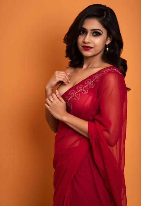 This photograph features a woman standing against a plain, warm-toned background, with her body angled slightly to the side. She is wearing a deep red, sheer saree that drapes elegantly over her body, revealing the outline of her medium-sized breasts through the fabric. The saree is adorned with intricate, golden embroidery near the chest area, adding a touch of elegance to the garment. Her left hand, adorned with a delicate ring, gently holds the saree's pleats, while her right arm is bent at the elbow, the hand resting against her side. The woman has light-brown skin and wavy, dark hair cascading over her left shoulder, hourglass body, wide hips. The lighting is soft and warm, casting gentle shadows that enhance the texture of the saree fabric and the subtle curves of her body. her eyes are deep dark, a little smirk in face.