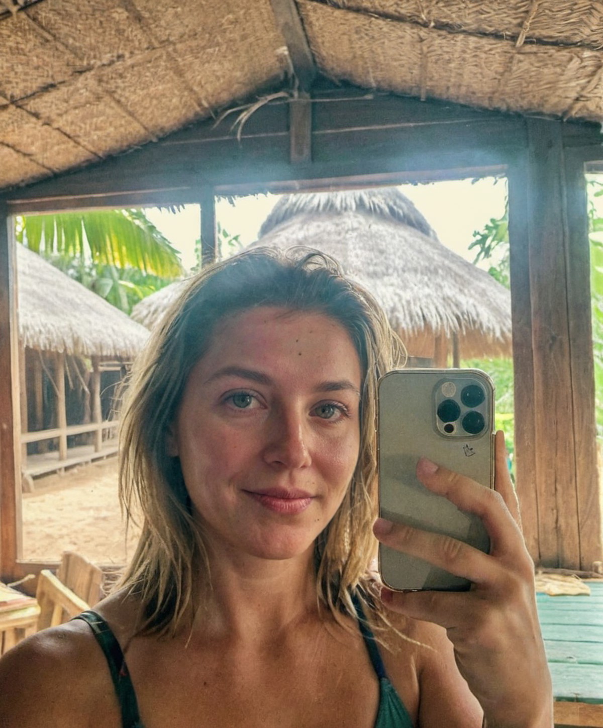 <lora:iphone_mirror_selfie_v01:1>
very grainy,
 iphone mirror selfie
woman holding iphone pro
in tropical hut, instagram p...