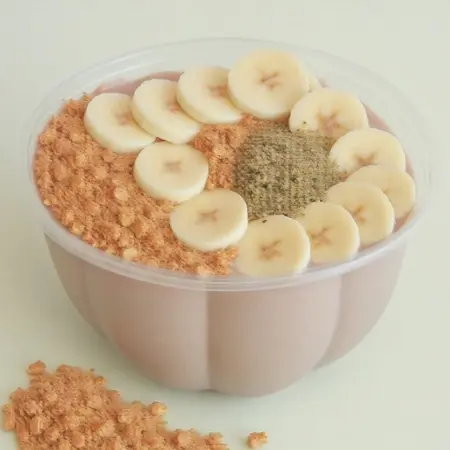 sks smoothie bowl made with almond milk, peanut butter, topped with banana slices, granola, and hemp seeds