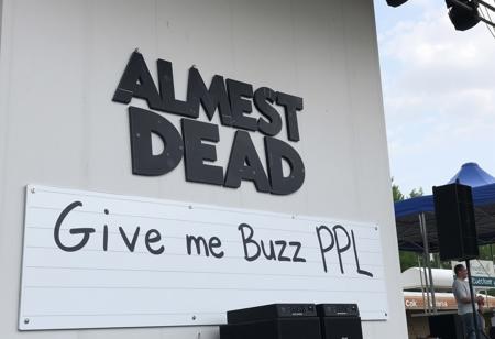 Joe Russo's Almost Dead Live at Summer Concert Stage at Island Waterpark on 2024-07-13, big Sign on wall says "Give me Buzz PPL"