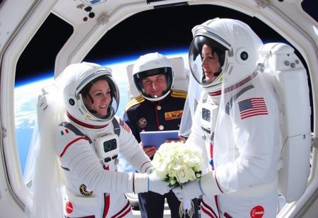 Astro-Brides, The first wedding in space, two women get married in spacesuits, a non-religious space commander officiates the wedding, both of the women have wedding veils on the outside of their spacesuits, in space, outside the spacecraft,