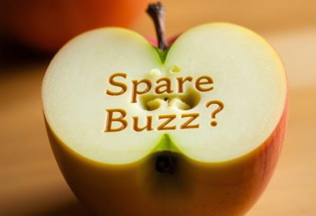 An image of an apple that is cut in half with the words "Spare Buzz?" Engraved in the inside.