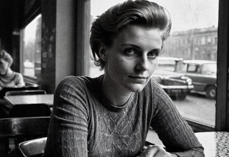 (((detailed face))) german woman 30 years old, perfect hands, sitting in a cafe in east berlin in 1962, watching outside, face in shadow, low light, full body shot from side, 1960 soviet look, dark mood, ilford hp5 plus 400, medium format camera,artsy, shadows, wide angle, contact test, damaged print, faded, grainy,blurry, pixelated, motion blur, vignette, high contrast