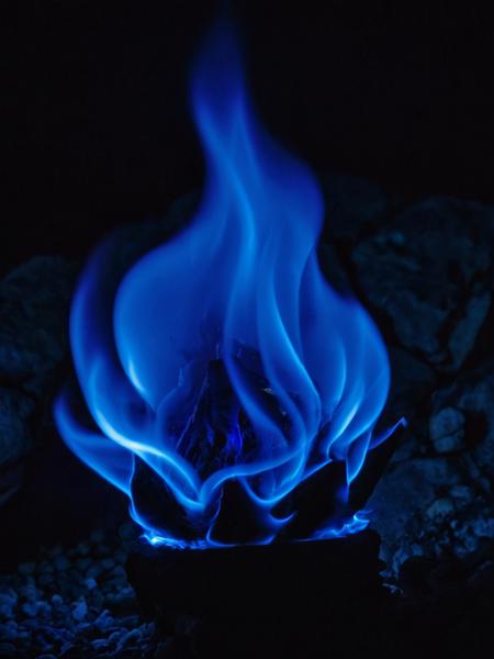 (closesup), sulfur lump burning with (big blue flame:3) at night, (blue glow), blue light