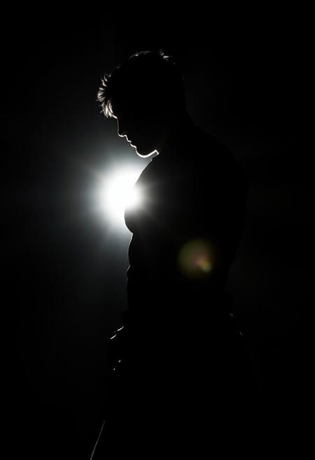Intensely backlit silhouette of a muscular-armed seeker in jet black. The light source creates deep shadows, highlighting layered textures. Abstract forms and expressive brushwork contribute to emotive storytelling and contemplative themes.
