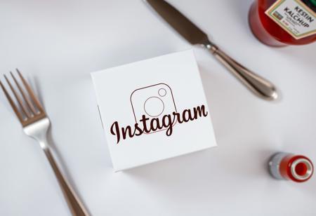photo of a white box with instagram logo, ((photography of square white box)) , ((centered subject)) , eye-level shot, direct angle, fork and knife, ketchup bottle, top_down , Advertising Style,