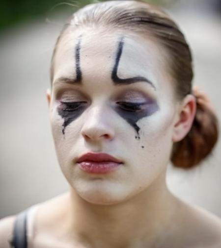 (close up face),color photo,25 years old,woman cmbkvacice,serious,frowning,mouth closed,(with mime makeup),on street,sunlit,highly detailed background,Fujifilm XT3,analog style <lora:IvaComeback_v1_1122_relib_cmbkvacice-000180:0.9>