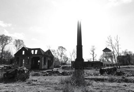 A lonely chimney of in the remains of former crematorium building. There are some ruined furnaces nearby. The background for the ruined, cold chimney is the bright daylight in the summer. No clouds, only hot August sun.
The picture is created in black and white watercolour technique, wherever possible black background is preferred.
The whole landscape is inspired by the atrocities of concentration camps and is the silent homage to the victims of the factories of death.