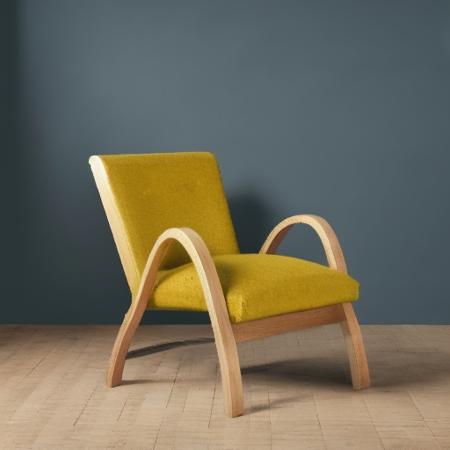 artek, Form-bent solid birch lamella, Solid birch and birch plywood, Fabric upholstery with steel springs and PU foam and polyester padding, Leather upholstery with steel springs and PU foam and polyester padding, a yellow chair with a wooden frame and arm rest and a yellow cushion on the back of the chair