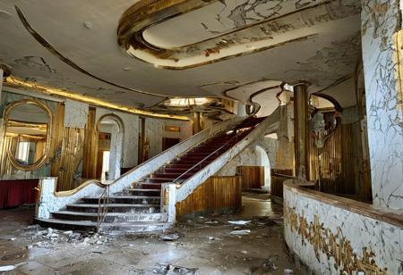 absurdres, high resolution, urbex derelict hotel lobby, porcelain walls,  gold detailing, art deco architecture,, cracked paint, sweeping staircase, hotel counter, broken windows, natural light, masterpiece, pmg style