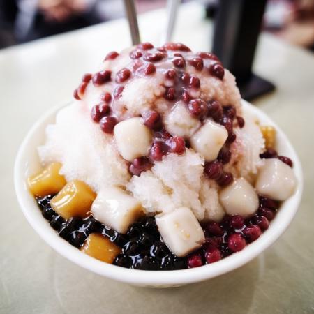 The image features a close-up of a bowl filled with a popular Taiwanese dessert often referred to as "boba tea ice" or "shaved ice." The bowl, which appears to be round and possibly white, contains a variety of toppings that may include cream, red beans, green beans, and possibly potato starch. A brown sauce is drizzled on top of the ice. The dessert is served with at least two spoons, suggesting it may be shared. The surroundings hint at the setting being a tea shop or a place where such desserts are commonly served, with other bowls in the background contributing to the atmosphere of the establishment. Despite the lack of text, the image seems to omit a casual and enjoyable vibe. , <lora:icetw:0.8>