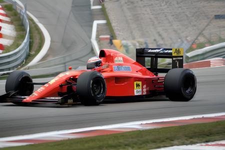 Photograph of the Ferrari 641 <lora:Ferrari 641 V1:0.75>, Formula 1 car, driver in car, race helmet, driving at race track, daytime, birds eye view shot, 8k, 4k, perfect lighting, high quality, masterpiece, 1990's, digital photograph, rich colors, retro, film grain, cool colors