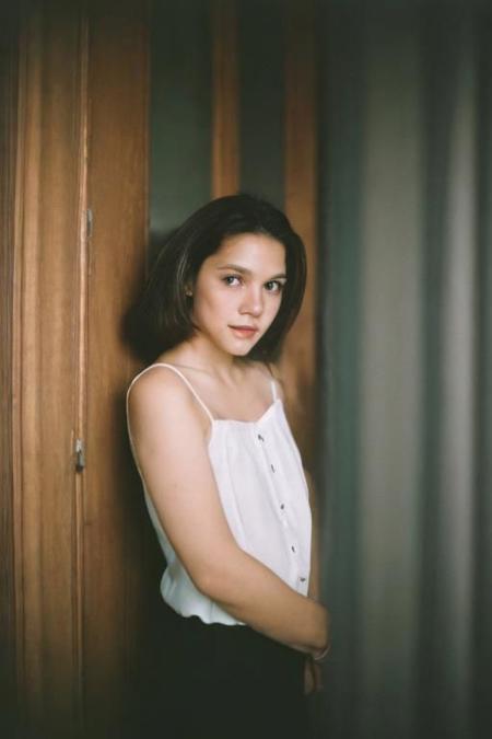 analog portrait photograph of a feminine french woman, dark room, Porta 160 color, shot on fujifilm, canon eos R