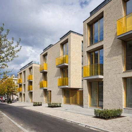 a raw photo of a modern mid-rise residential building with a rectangular form and clean, boxy façade. The exterior is clad in light-colored stone panels, with balconies featuring glass railings and vibrant, color-accented interiors visible in red, green, and yellow shades. Located on a street corner in an urban setting with minimal trees and street furnishings, the building is shown during daytime with partly cloudy skies.<lora:epi_noiseoffset2:5> <lora:ModernArch_Residence_XL_V1:0.68>