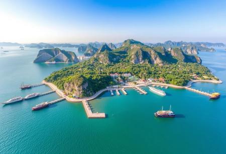 Yinyue Island is a tourist destination with a view of ships on the sea. The island has a radius of 2 kilometers and is crescent shaped with many mountains. It is surrounded by the sea and has attractions such as docks and villas.