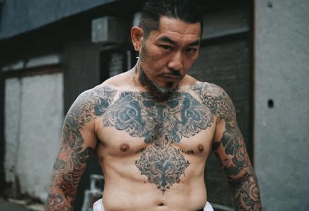 leica m3, 35mm Voigtlander lens, Portra 160/400, photograph of Yakuza boss, full body Japanese demon Tattoo, high contrast, clear face, natural  sunlight