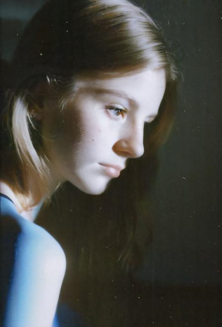 FP100C, Portrait, womans bedroom scene, portrait photo of stylish 21yo Canadian woman, soft facial features, perfect detailed eyes, natural skin, (hard shadows:.81), prismatic light, grainy, shadows, spotlight, sensual, voyuerism <lora:FP100C_frameless:.91>