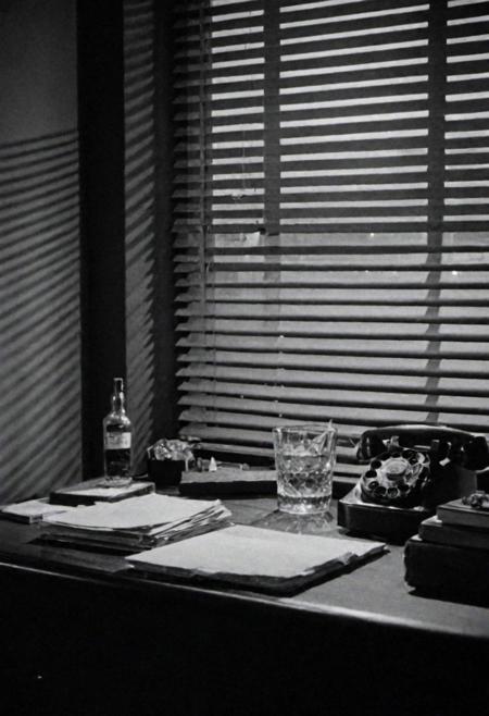 In the 1950s in Chicago, Night, interior of a private detective's office, desk on a bottle of Whiskey, cigarette smoke and little light coming through the blinds on the window. Captured on a 35mm camera, black and white, classic film.
inside