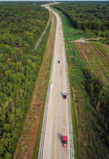 An ais-abandz Controlled-access highway with center Median extending into the distance, woods, cars, trucks, 4k, uhd,masterpiece, ground level view