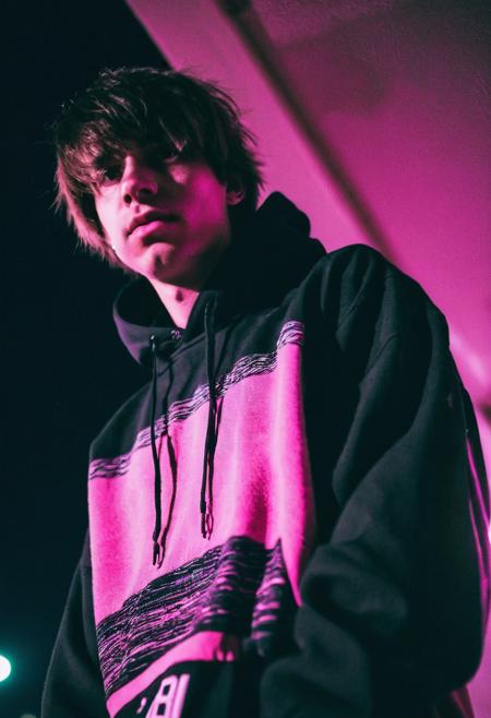 go pro photo, half body,1man, 25 y.o. , low angle, night , bright clothes 90's, grainy photo, analogue glitch effect, emo, black and pink colors in clothes