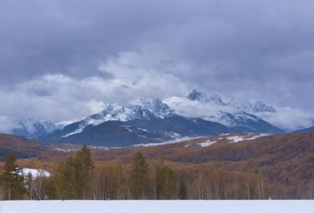 (a large body of water with snowy mountains in the background), (fog, foggy, rolling fog), (clouds, cloudy, rolling clouds), dramatic sky and landscape, extraordinary landscape, (beautiful snow capped mountain background), (forest, dirt path)