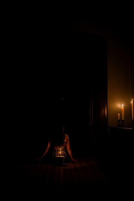 RAW photo, 8k uhd, dslr, high quality, film grain, Fujifilm XT3.
View from behind, dim horror movie lighting, 1woman, kneeling in front of a candle lit alter, in a dark mansion, old home