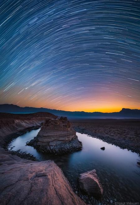啎䥃佄䔀Capture the enchanting beauty of the transition from day to night, known as the blue hour, over a serene landscape with star trails in the style of Michael Shainblum, using a Pentax K-1 Mark II camera with a Pentax D FA 24-70mm f/2.8 ED SDM WR lens. Position yourself to take advantage of the soft, diffused light of the twilight sky as it illuminates the landscape, casting long shadows and creating depth in your image. Experiment with different focal lengths to find the perfect composition, and use a tripod for stability during long exposures. Focus on the interplay of light and shadow, highlighting the rich textures and colors of the landscape under the twilight sky and star trails. Utilize the cool tones of the blue hour to create a moody and atmospheric quality in your image. Post-process your image using techniques such as selective color grading and contrast adjustments to enhance the mood and atmosphere of the scene, creating a captivating and enigmatic photograph that embodies the essence of twilight transcendence with star trails in the style of Michael Shainblum.
