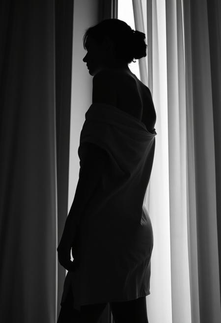 black and white fine art photography, a woman standing by a tall window, her silhouette outlined by soft diffused light, wearing a loosely draped satin sheet, moody chiaroscuro lighting, capturing the curve of her back and shoulders, close-up framing, low-angle shot, setting: minimalist loft with sheer curtains billowing, mood: enigmatic and poetic, lighting: high contrast with delicate highlights, color theme: monochrome, camera: Leica M6, in the style of Peter Lindbergh