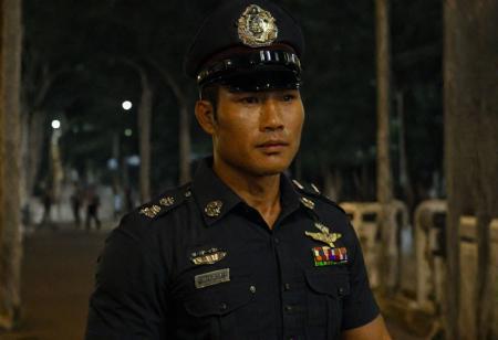 upper body, cinematic still of 30 year old handsome muscular Thai man in police uniform and hat, standing in Bangkok streets, highly detailed, intricate details, shallow field of depth, cinematic lighting