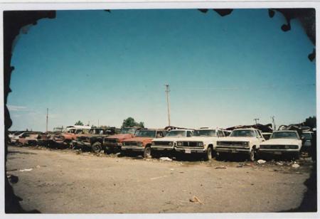 junkyard, detailed,  polaroid sx-70 film, wide angle, pixelated, scratched, high iso noise