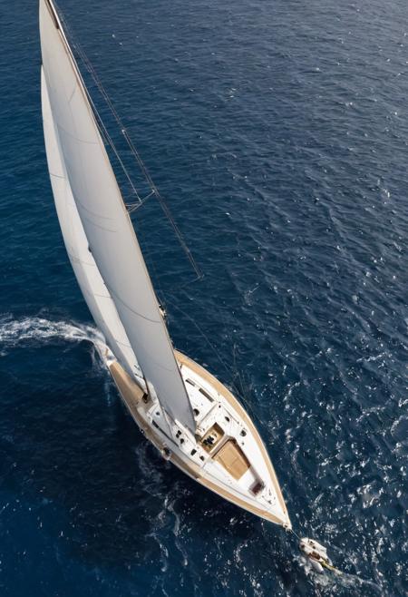 aerial shot, white, blue and gold colored racing yacht in a regatta, azure blue waters