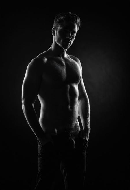 Create a captivating black and white portrait that emphasizes the dramatic outline of a man's figure. Set the scene with a dark backdrop and strategically placed strobe lighting to create harsh shadows and intense highlights. Position the man in a powerful stance, with his body angled to create intriguing shadows and contours. Capture the scene in monochrome, accentuating the contrast between light and shadow. The stark black and white tones will add depth and emotional intensity to the image. Utilize a Canon EOS R5 and a 70-200mm f/2.8 lens to isolate the subject and create a shallow depth of field, blurring the background and drawing full attention to the man's striking silhouette. The dramatic lighting and monochrome toning will evoke a sense of mystery, intrigue, and artistic depth, resulting in a powerful and evocative portrait that conveys a range of emotions through the simplicity of shadows and light.