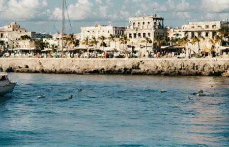 amateur photo of (Havanna:1.2), Cuba in the (1970ties:1.3), (coast and sea:0.9), colorful buildings, panorama, palm trees, (old city:1.1), sea, cliffs, beach, azure, bay, sunny, no clouds, cinematic lighting, golden hour, god rays, 8K, (highly detailed:1.5), (ultra-realistic:1.5), Kodak,  (ag200:1.2) (film grain) <lora:Analog Style Agfa:0.88>
