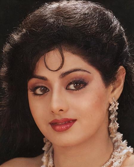 photo of a sridevi woman in a dynamic pose wearing elegant high-neck Kalamkari Dress (hand-painted fabric) looking at camera with Bite lower lip in anticipation expression, film grain, perfect eyes, at a flower garden beautiful bokeh <lora:Sridevi_SD15_LoRA_prodigy_local_regs-000002:1>