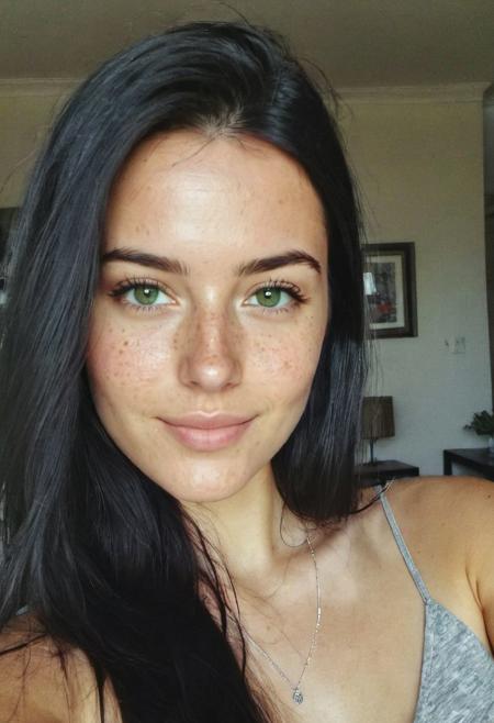 instagram selfie , a 23 year old gorgeous woman , slight smile , detailed skin face and eyes , natural lighting , at home , long black hair, wearing a silver necklace, film grain, low contrast, natural face , freckles , black hair , green eyes, dark circles under eyes