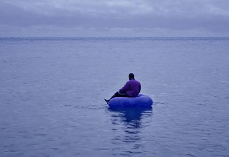 A Blue Ocean, With A Lone Figure Sitting On A Blue Inflatable Raft, sadness, lonely, blue, purple, feelings, misery, broken, frustration, sorrow, depression,  Blue And purple Tones
