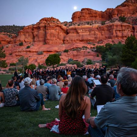 couples on a large lawn in front of a wall of natural red rock formation, listening to an orchestra on a warm summer night in the foothills, half moon, sitting resting on hands, some snuggling, one couple kissing,  conductor smiling, close up on conductor