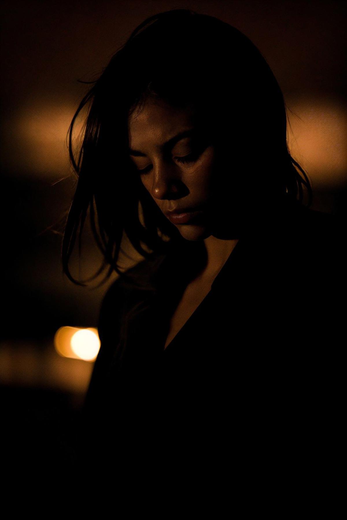 A woman with long brown hair and a black shirt.