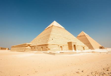 Low angle wide view of ancient Egypt in it's prime, desert, the pyramids are as described by contemporaries: white with limestone and capped with gold, reflecting the strong African sunlight to the point that they are hard to look at