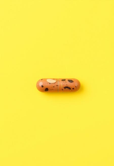 simple background, food, no humans, yellow background, yellow theme, still life, pill