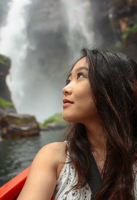 lovely Asian woman at Iguazu Falls, Argentina, in a boat near the base of the falls, looking up at waterfall coming down, mist covering everything, especially her face and hair hair. close up on face and falls.