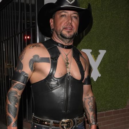 Jasonaldean person wearing a gay pride ((tight leather bodysuit)) alone outside a ((small town gay nightclub in texas)), ((lipstick)),