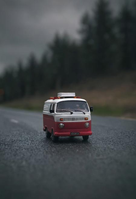 macro shot of a toy van on road with dark moody cinematic effect, gradual blur effect, aesthetic mood.