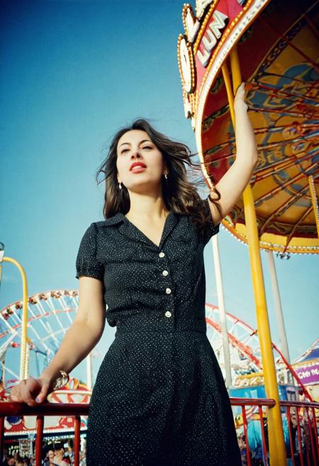european woman 25 years old at luna park, cinestill 800t film, from side and below, artsy, harsh shadows, ulta wide angle, flash,overexposed, faded, grainy,blurry, pixelated, motion blur, vignette