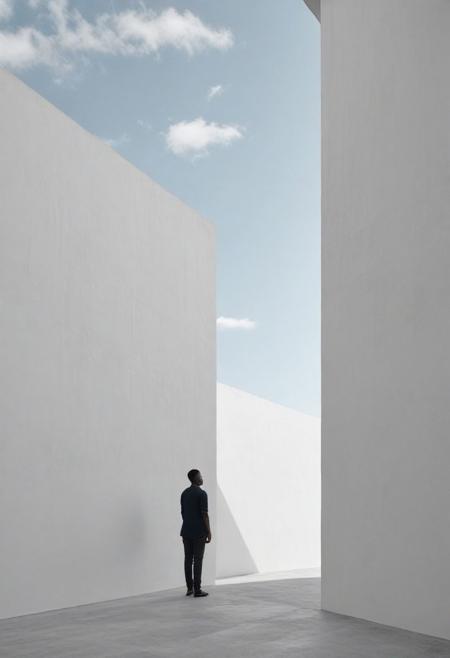 Create a minimalist black and white photograph featuring a black person standing against a white wall with only a vast expanse of blue sky as the background. Emphasize the subject's presence by positioning them within the negative space, allowing the emptiness to enhance their significance. Utilize the monochromatic palette to evoke a sense of starkness and simplicity, drawing attention to the subject's form or details against the backdrop of the sky and wall. Focus on the purity of composition to evoke a feeling of serenity and contemplation.