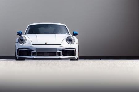 low angle shot of a (Porsche911_ti),dark blue sports car, (in a white studio cove:1.2), realistic digital render, 75mm lens,canon mark 3, reflective floor, rim light