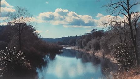 (((landscape of a river and trees in the distance with a blue sky in the background and a few clouds in the sky, 1980s movie footage vhs movie, high contrast)))<lora:Vintage_Street_Photo:1.0>